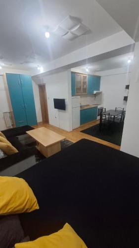 un soggiorno con un tavolo e una cucina di Romansa Apartment a Skopje