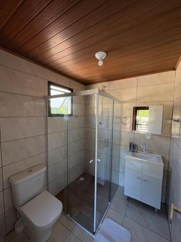 a bathroom with a toilet and a shower and a sink at Cobertura Vista mar com churrasqueira in Governador Celso Ramos