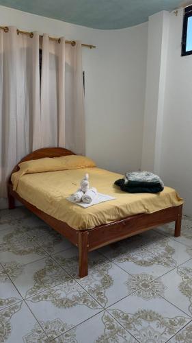 a bed with a teddy bear sitting on top of it at Casa JIREH in Puerto Ayora