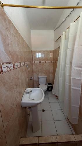 a bathroom with a sink and a toilet at Casa JIREH in Puerto Ayora