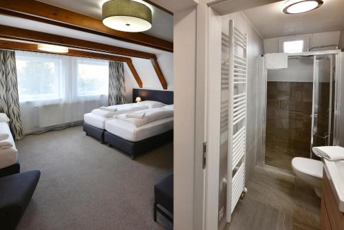 een slaapkamer met 2 bedden, een douche en een badkamer bij Penzión Chata Valaška in Stary Smokovec