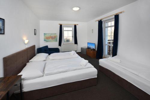 twee bedden in een kamer met twee ramen bij Penzión Chata Valaška in Stary Smokovec