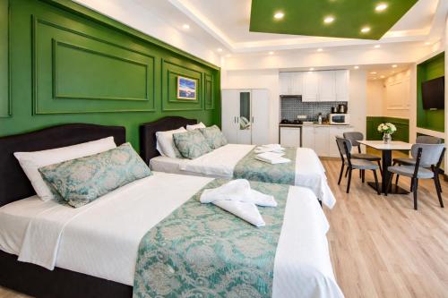 two beds in a room with green walls and a table at Valentina Apart Hotel in Istanbul