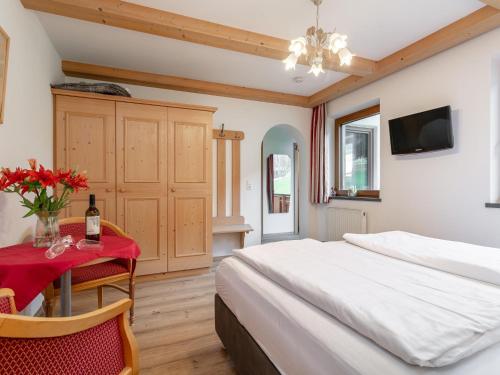 - une chambre avec un lit et une table avec une bouteille de vin dans l'établissement Landhaus Marchfeld Top 1, à Wildschönau