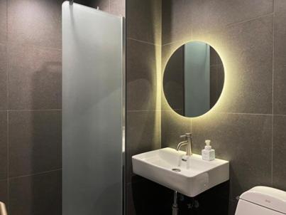 a bathroom with a sink and a mirror and a toilet at Hotel MERV in Seryu-dong