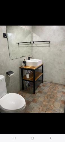 a bathroom with a white toilet and a sink at Las casitas de Canggu in Canggu