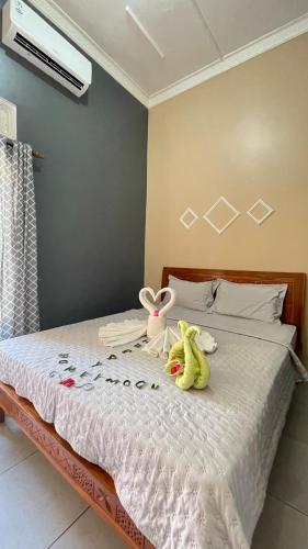 two stuffed animals sitting on top of a bed at Asta Homestay in Karimunjawa