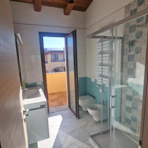 a bathroom with a glass shower and a toilet at Casa Toni, Villasimius in Villasimius