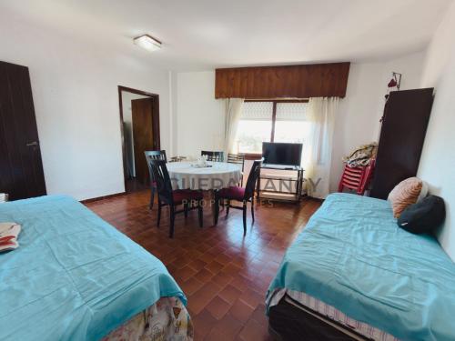 ein Zimmer mit zwei Betten und einem Tisch und Stühlen in der Unterkunft Urquiza 263 P4 SB in San Bernardo