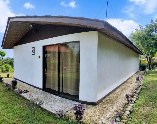 una piccola casa bianca con tetto nero di Hills Villa Rio Celeste a Rio Celeste