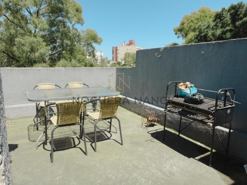 einen Tisch und Stühle neben einem Zaun in der Unterkunft Urquiza 263 P4 SB in San Bernardo