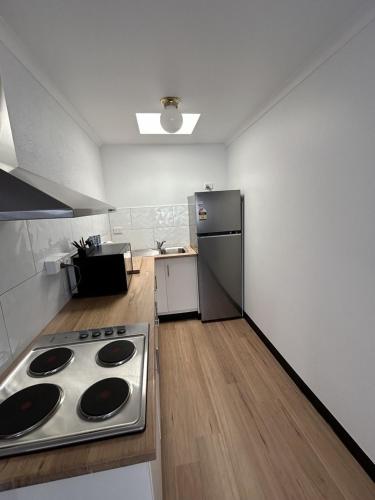 a kitchen with a stove and a stainless steel refrigerator at Comfort Inn Devonport in Devonport