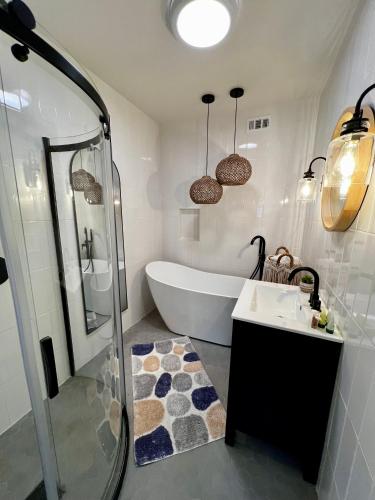 a bathroom with a tub and a sink and a shower at Beachwalk Villas in Carlsbad