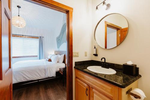 ein Badezimmer mit Waschbecken, Bett und Spiegel in der Unterkunft Kintla Ridge Suite Near Logan Hospital in Kalispell