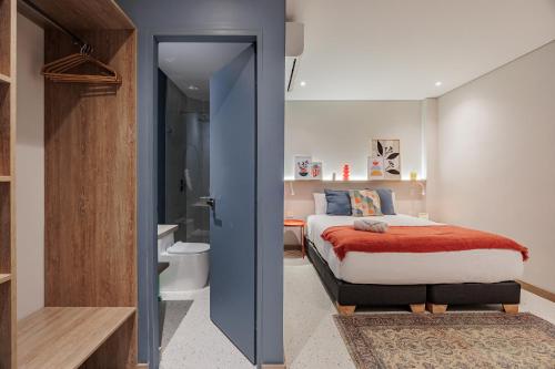een slaapkamer met een bed en een badkamer bij Medellinn The Blooming Hotel in Medellín