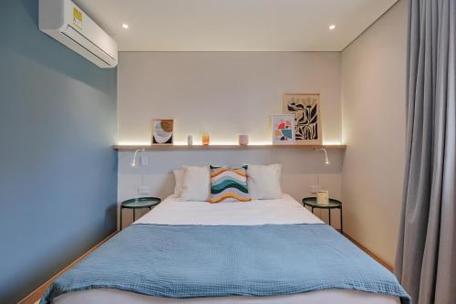 een slaapkamer met een bed met een blauwe deken bij Medellinn The Blooming Hotel in Medellín