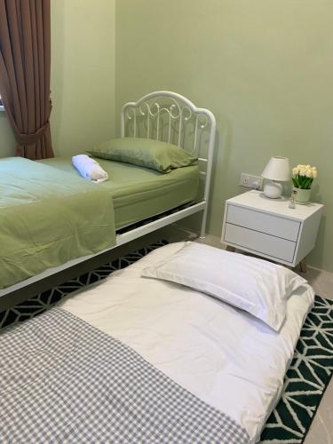 two twin beds in a bedroom with a night stand at RusanHome Pengkalan Chepa in Pengkalan Cepa