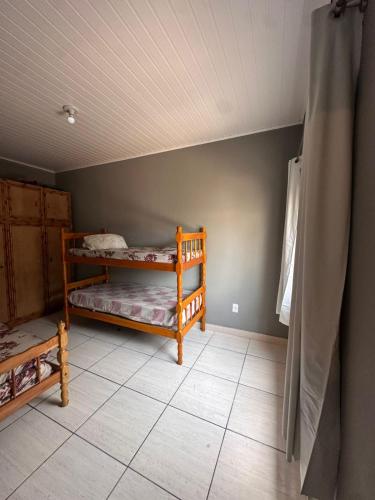 a bedroom with two bunk beds in a room at Apartamento Amplo em Tramandaí in Tramandaí