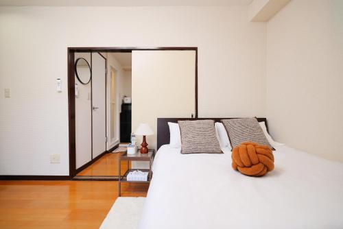 een wit bed met een oranje knuffeldier erop bij 3 min JR Direct to Skytree Asakusa Shinjuku Sea Heim in Tokyo