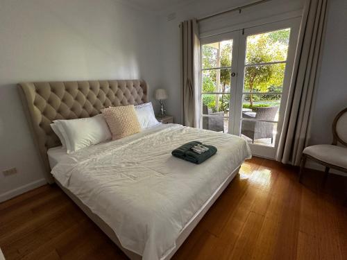 una camera da letto con un letto grande con una grande finestra di Entire Beachfront Vacation House a McCrae