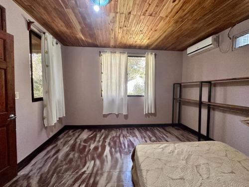 een lege kamer met een bed en een raam bij PachaMama Bio in Tamarindo