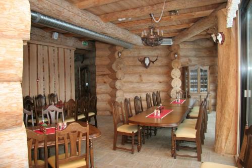 uma sala de jantar com paredes e mesas e cadeiras de madeira em Greete Motel em Soontaga