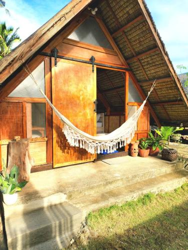 a house with a hammock in front of it at Duon Baler - Seconds from Sabang beach, your peaceful escape in Baler