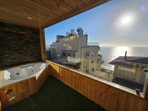 une baignoire dans une pièce avec une grande fenêtre dans l'établissement Al Mar Cabañas, à Viña del Mar