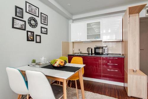 eine Küche mit einem Tisch mit einer Obstschale darauf in der Unterkunft Wolf Apartments Kopaonik in Kopaonik