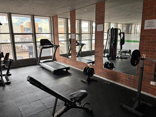 een fitnessruimte met loopbanden en gewichten in een gebouw bij Luxury, Comfort central área in Pasto