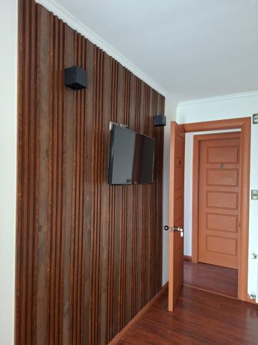 una TV a schermo piatto a parete in camera di Refugio de Caty a Bahía Mansa