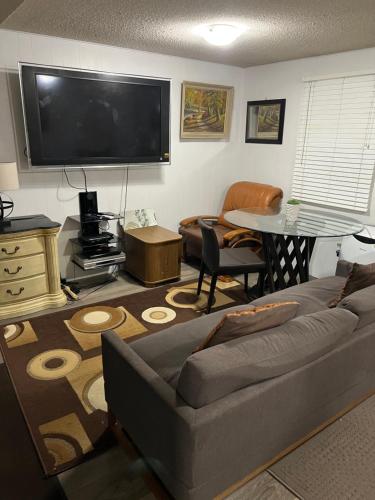 a living room with a couch and a flat screen tv at Pau-Rae's Cozy Spot - your home away from home! in Thornhill