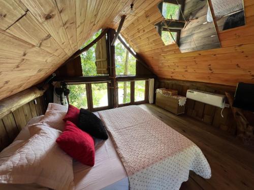 a bedroom with a bed in a wooden cabin at Chalé dos Alves in Morro Azul