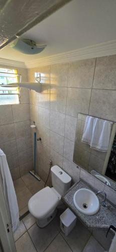 a bathroom with a white toilet and a sink at Tesouro da Maraponga in Fortaleza