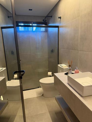 a bathroom with a shower and a toilet and a sink at Amélia Pousada de Charme in Porto De Galinhas