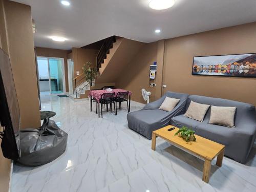 a living room with a blue couch and a table at Urban Ease Hatyai in Hat Yai