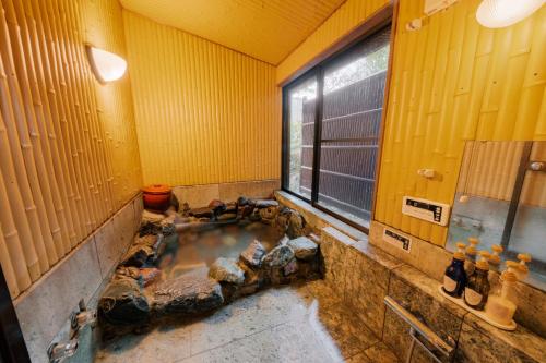 a dirty bathroom with a tub in the middle at 樹-Itsuki- "岩風呂付 rockbath" in Hakone