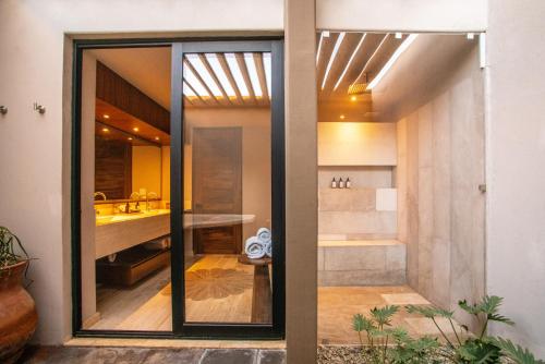 bagno con porta a vetri che conduce alla doccia di Hotel Flores de Sal-Valle de Guadalupe a Valle de Guadalupe
