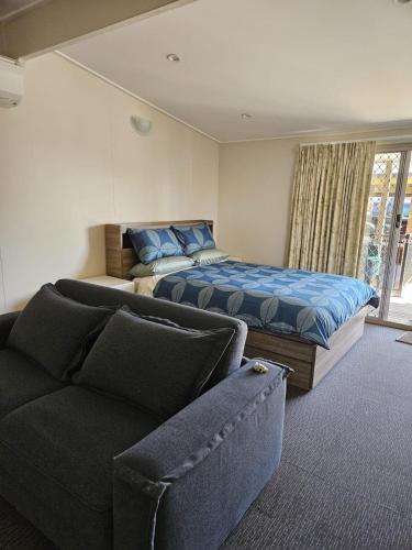a bedroom with a bed and a couch and a bed at Silver Sands Tourist Park in Lakes Entrance