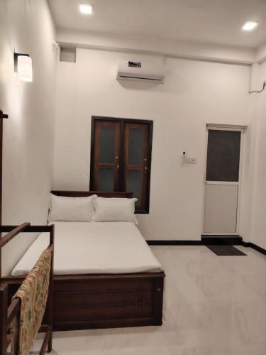 a bedroom with a bed in a white room at Cinnamon Shade by Achievers in Negombo
