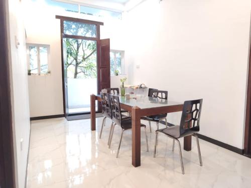 a dining room with a wooden table and chairs at Cinnamon Shade by Achievers in Negombo