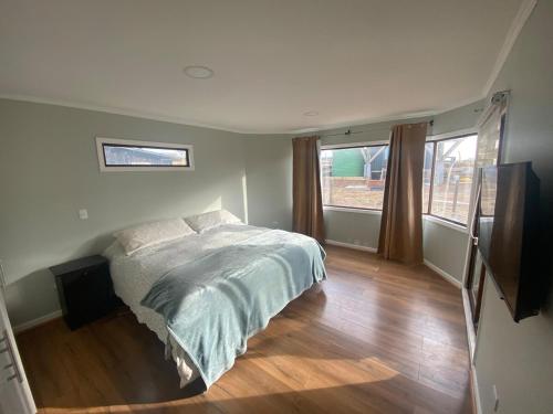 een slaapkamer met een bed en een groot raam bij Great house in Punta de Lobos in Chacurra