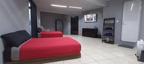 een slaapkamer met een rood bed in een kamer bij La Patrona Hostal in Santa Cruz Xoxocotlán