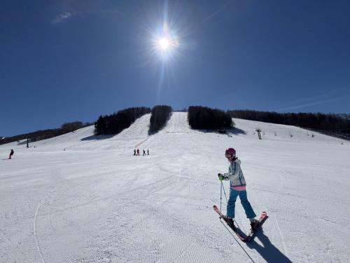 a person on skis on a snow covered slope at ゲストハウス弓と糸 Guesthouse Yumi To Ito 2F in Nagano