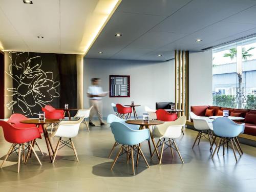 a restaurant with red and blue chairs and tables at ibis Bangkok IMPACT in Nonthaburi