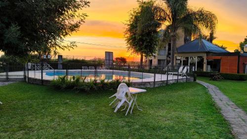 una sedia bianca seduta sull'erba accanto a una piscina di Vía Verde a Gualeguaychú