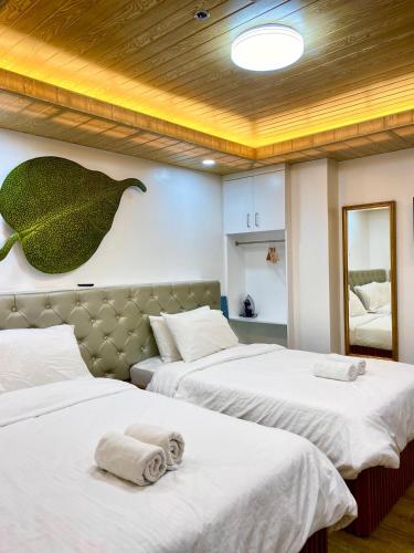 a bedroom with two beds with towels on them at Nica's Palace Baguio in Baguio
