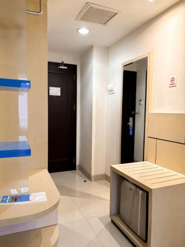 a room with a tv and a hallway with a door at Hotel Brothers Solo in Solo