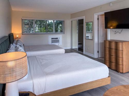 una camera da letto con due letti e una TV a schermo piatto di Ocean Lodge a Boca Raton