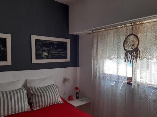 una camera da letto con un letto rosso e una finestra di Marbella 1 a San Bernardo